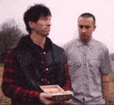 a man in a plaid shirt is holding a box that says ' x ' on the front