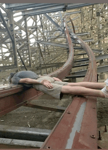 a person laying on the tracks of a roller coaster that says ' a ' on the side