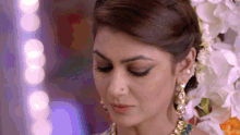 a close up of a woman 's face with her eyes closed and a nose ring
