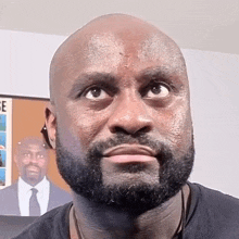 a bald man with a beard is making a funny face