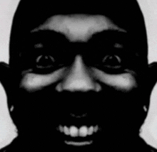 a black and white photo of a man 's face with a smile on his face .