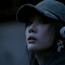 a close up of a woman wearing headphones and a hat with the letter o on it