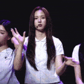 a girl with long hair is wearing a white shirt and a microphone