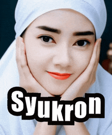 a woman wearing a white head scarf has her hands on her face and the word syukron is on the bottom