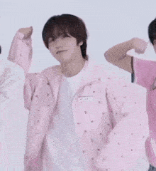 a man in a pink jacket is dancing with two other men .