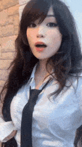 a woman with long hair is wearing a white shirt and a black tie .