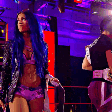 a woman with blue hair is standing in a ring with a belt that says ' smackdown ' on it
