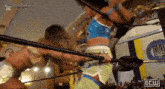 a couple of women are wrestling in a ring with a crowd watching .