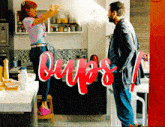 a man and a woman are standing in a kitchen with the word oops written in red