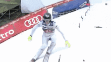 a person is skiing down a snowy slope with an audi sign in the background