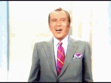 a man in a suit and tie with a purple pocket square
