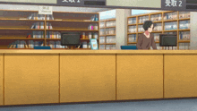 a man stands behind a counter in a library with a sign above him that says premium