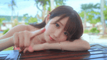 a woman in a pink bikini is laying on a wooden table