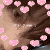 a close up of a person 's face with pink hearts around it and the words `` chan d mar '' .