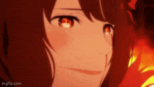 a close up of a girl 's face with red eyes and a fire background .