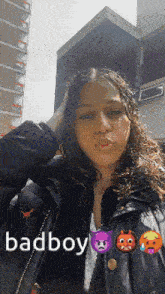 a girl is wearing a black jacket and has the words badboy written on her face