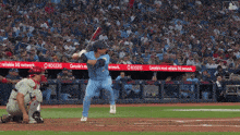a baseball player is swinging at a ball with rogers ads behind him