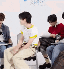 a group of people are sitting in chairs in front of a whiteboard .