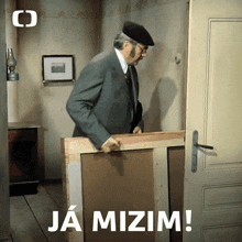 a man in a suit is holding a piece of wood with the words ja mizim written above him