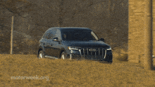 a black audi car is driving down a road