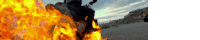 a person is riding a motorcycle in front of a large fire
