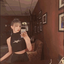 a woman taking a picture of herself in front of a rainbow background