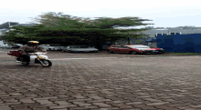 a man riding a motorcycle on a brick road