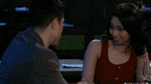 a man and a woman are sitting at a table with their arms crossed