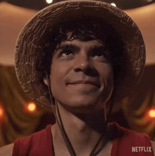 a man wearing a straw hat and a red shirt with netflix written on the bottom right