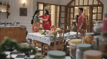 a family is gathered around a table in a kitchen .