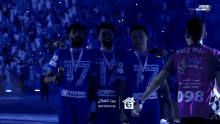 three soccer players are posing for a picture with medals around their necks and one of them has the number 17 on his shirt