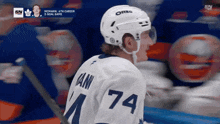 a hockey player wearing a white jersey with the number 74 on it
