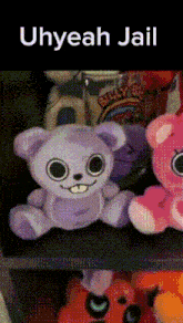 a purple teddy bear is sitting on a shelf next to other stuffed animals