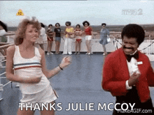 a woman is dancing next to a man in a tuxedo on a boat .