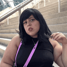 a woman wearing a black top and a lanyard with the letter j on it