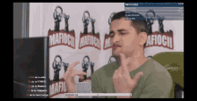 a man giving the middle finger in front of a microphone in front of a wall that says mafioch on it