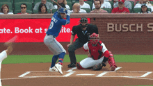a baseball player is swinging at a pitch while a busch advertisement is behind him