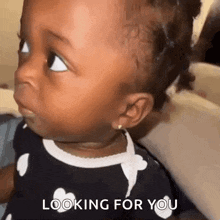 a baby girl is looking at the camera with the words `` looking for you '' written on the bottom .