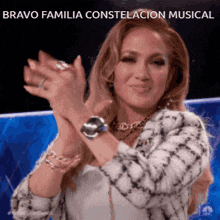 a woman is applauding with the words bravo familia constelacion musical behind her