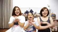 a girl wearing a shirt that says " hate " is dancing with two women