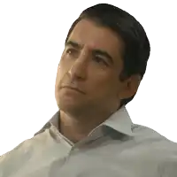 a man in a plaid shirt looks to his left with a serious look on his face