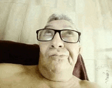 a man wearing glasses is making a funny face .