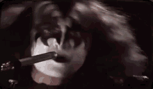 a close up of a woman 's face with a cigarette in her mouth .