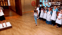 a group of people are standing in front of a wall that says masterchef on it