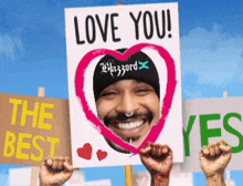 a man holding a sign that says love you on it