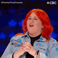 a woman with red hair is wearing a denim jacket with hayley written on it