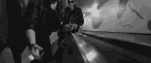 a group of people are walking down an escalator in a dark room .