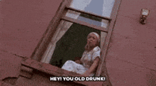 a woman is sitting on a window sill and saying hey you old drunk