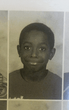 a black and white photo of a boy with a smile on his face