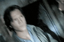 a blurry picture of a man standing in a dark room with a microphone in his hand .